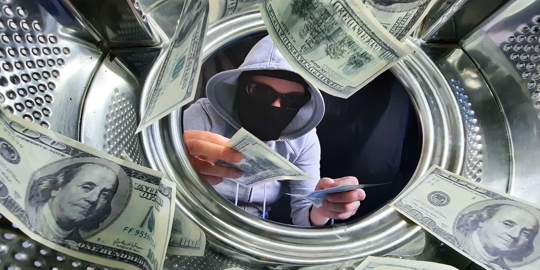 Cash in washing machine with masked figure holding bill